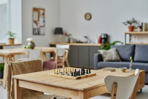 Chess board set up on table in living room / kitchen area. Intended to show casual setup for chess lessons at home